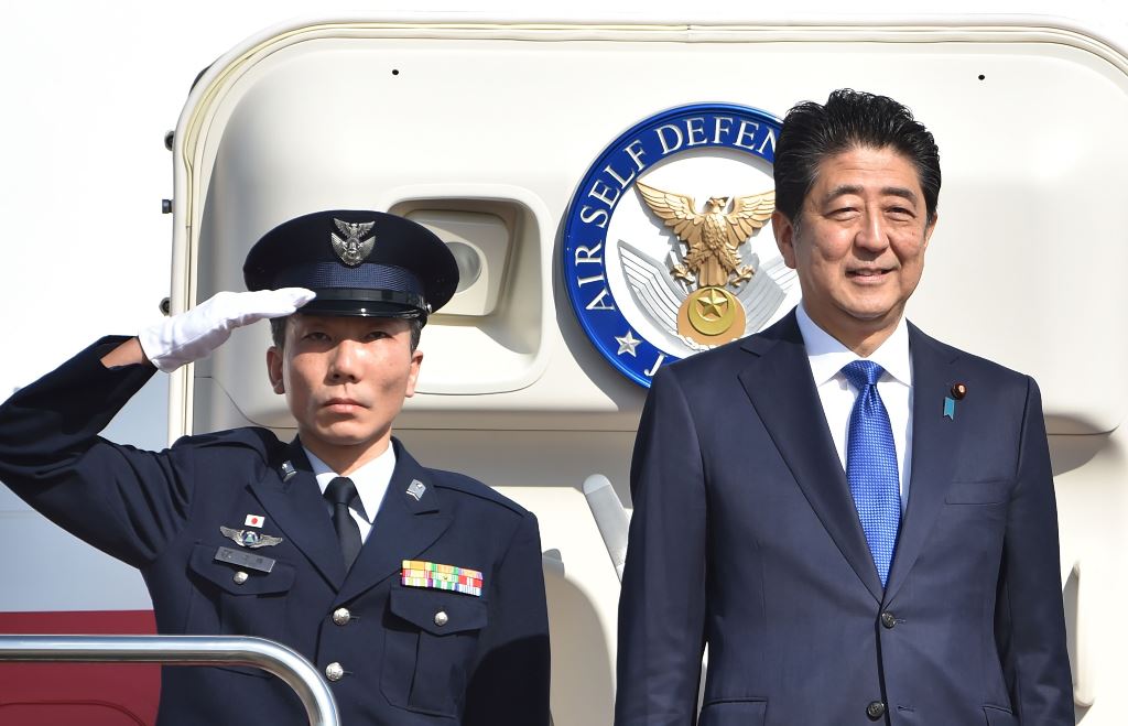 Japan's Prime Minister Shinzo Abe (R) leaves Tokyo's Haneda Airport on November 17, 2016. AFP / KAZUHIRO NOGI