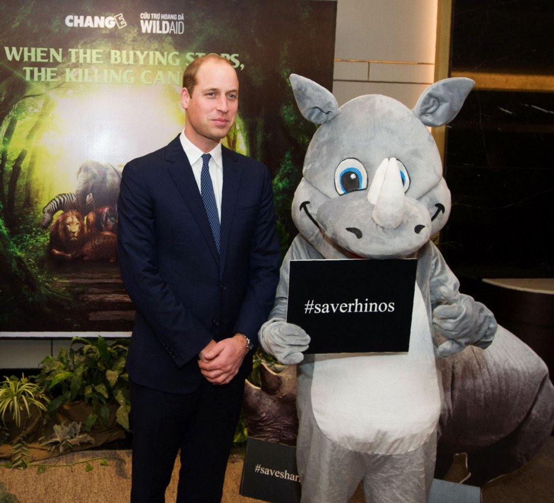Britain's Prince William, Duke of Cambridge poses with an activist dressed as a white rhinoceros after delivering a speech at the Hanoi conference on illegal wildlife trade being held in Hanoi on November 17, 2016. AFP / STR