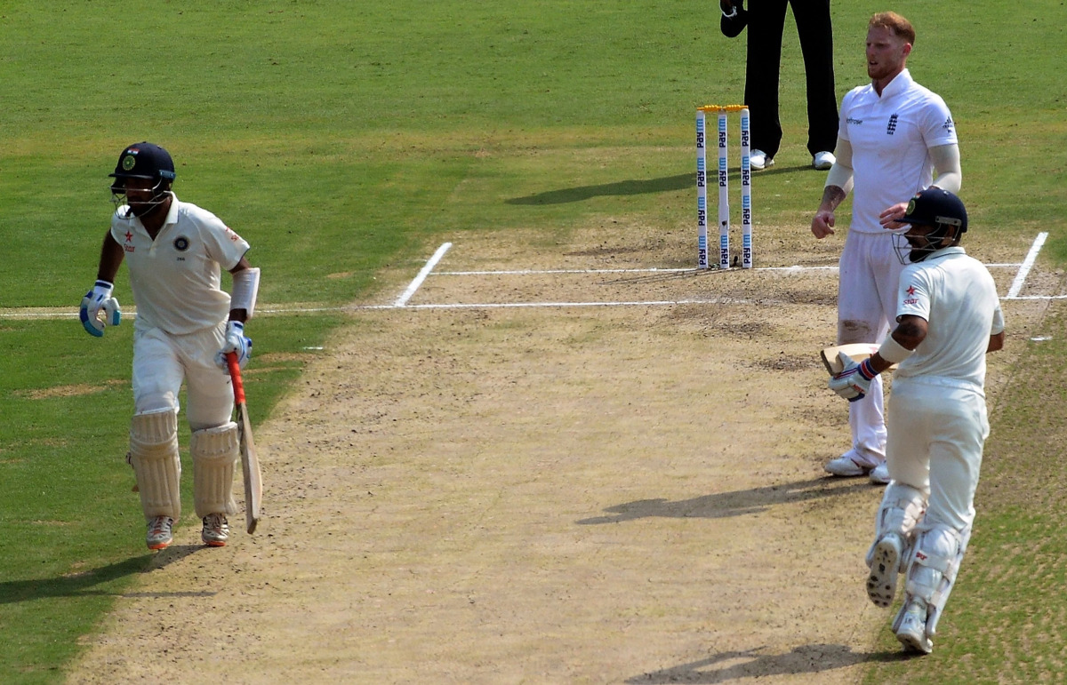 England's Ben Stokes (2R) watches as India's Cheteshwar Pujara (L) and Virat Kohli (R) run between the wickets during the first day of the second Test cricket match between India and England at the Dr. Y.S. Rajasekhara Reddy ACA-VDCA Cricket Stadium in Vi
