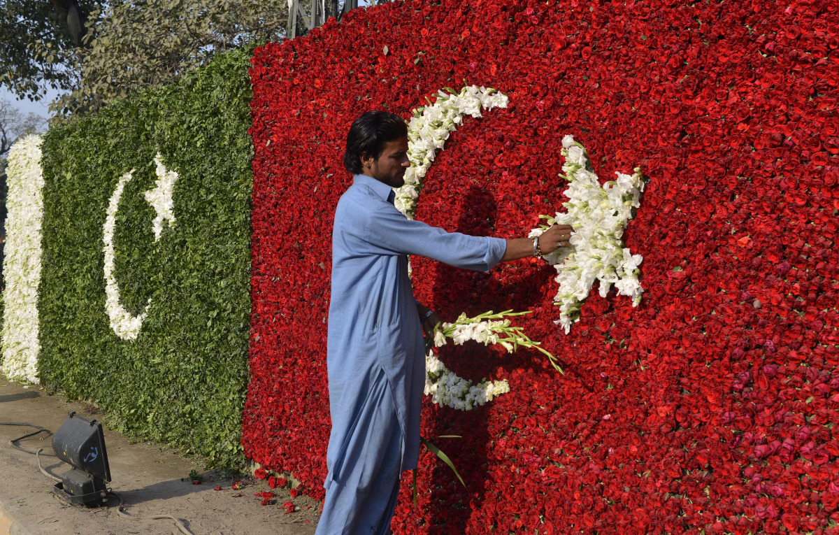 A Pakistani worker decorates a welcoming Turkish national flag with flowers on the arrival of Turkish President Recep Tayyip Erdogan in Lahore on November 17, 2016. Turkish President Recep Tayip Erdogan is in Islamabad on a two-day official visit to meet 