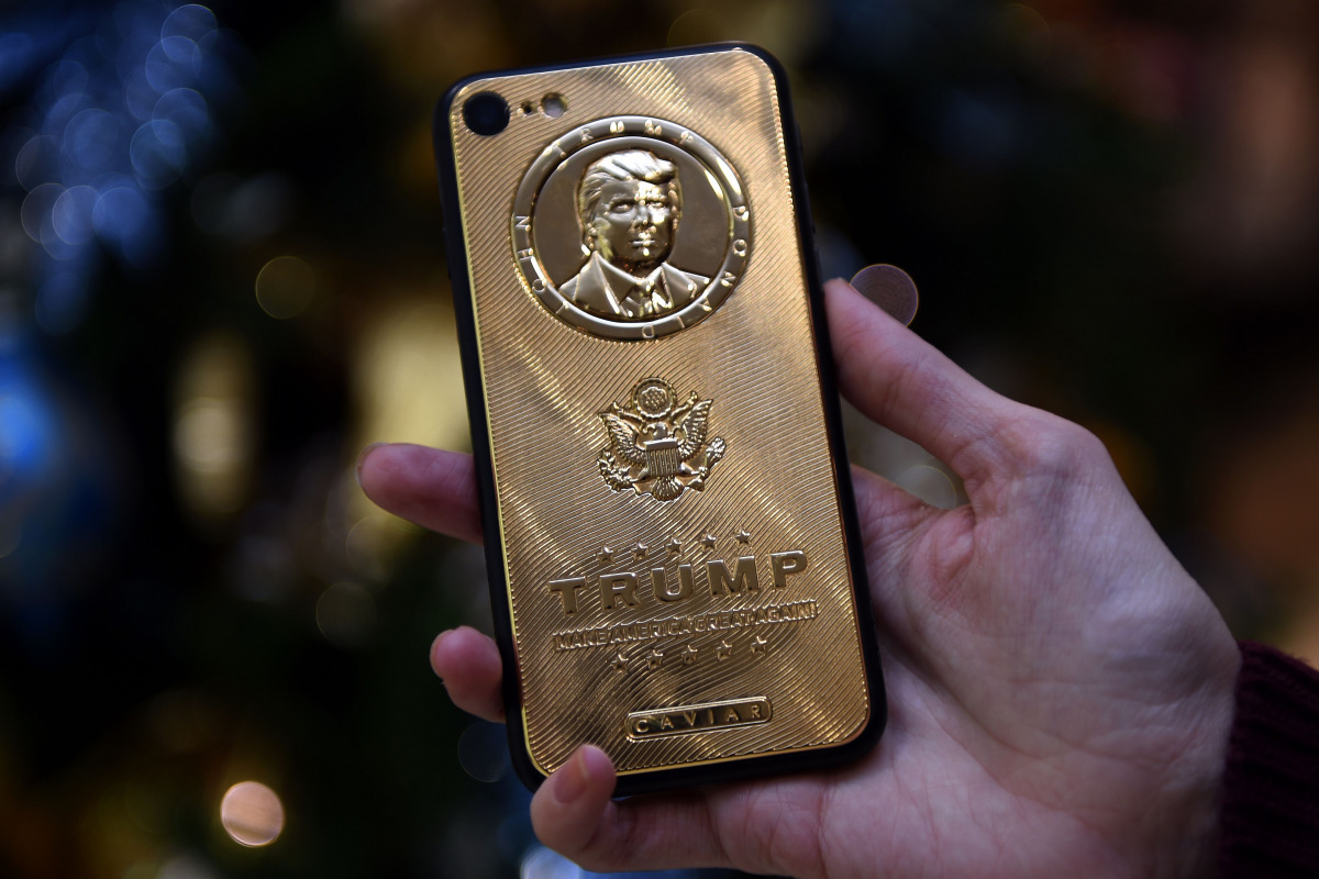 REPRESENTATIVE IMAGE: An employee of Caviar Phones, a Russian-Italian company specializing in smartphone customization, displays a special gold-plated iPhone 7 smartphone bearing the likeness of US President-elect Donald Trump - at a minimum price of 197 