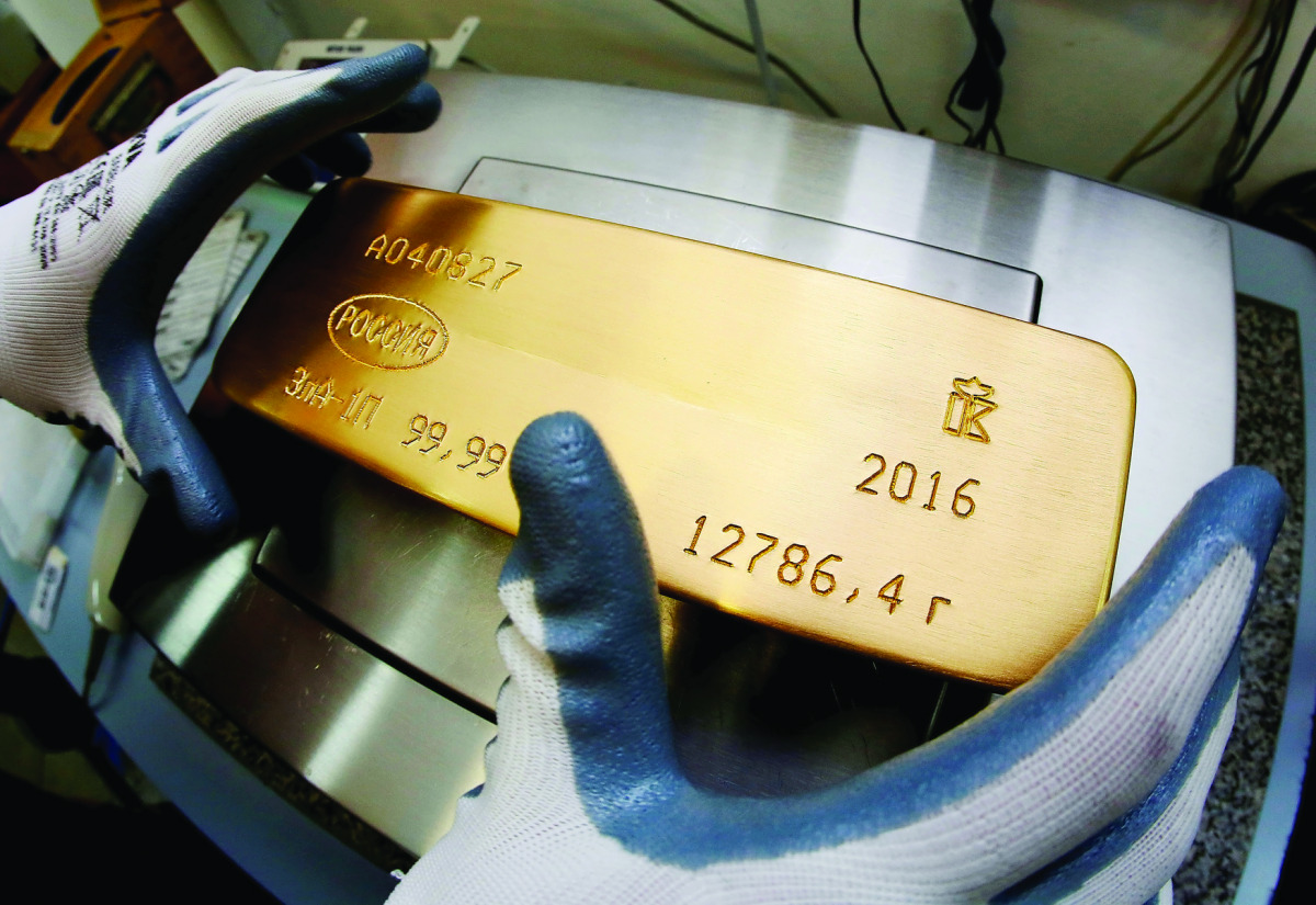 An employee weighs an ingot of 99.99 percent pure gold on the scales at the Krastsvetmet non-ferrous metals in Krasnoyarsk, Russia.