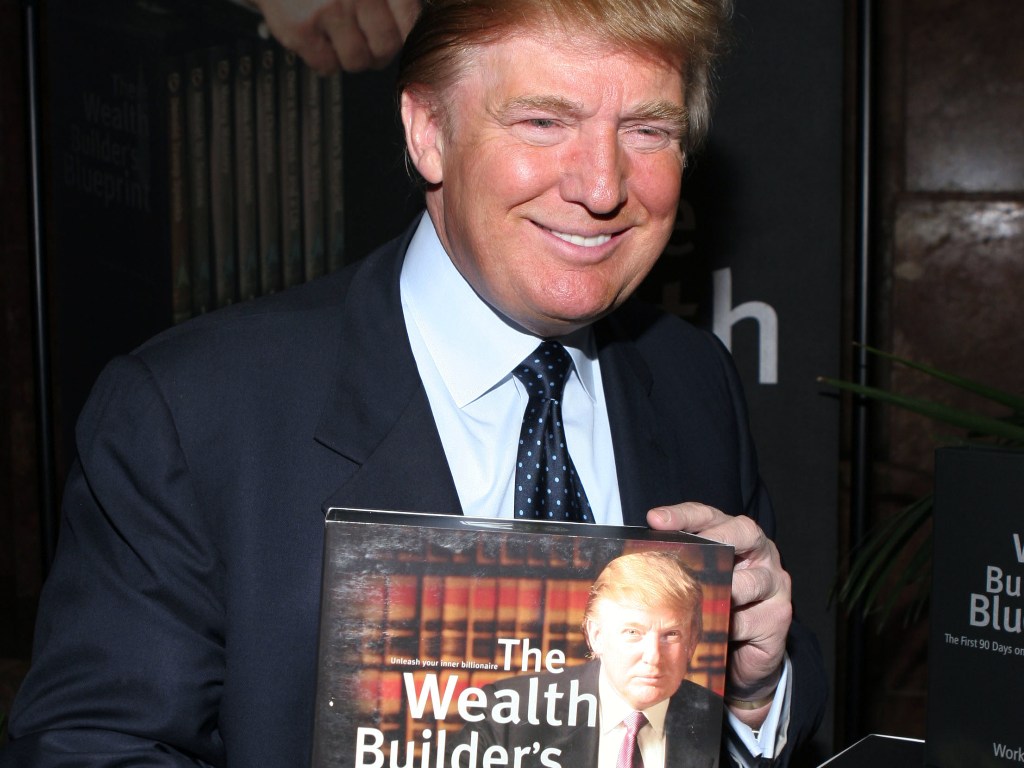 (FILES): This file photo taken on May 22, 2005 shows real estate mogul Donald Trump holding a book at a media conference announcing the establishment of Trump University in New York City.  AFP / Thos Robinson
