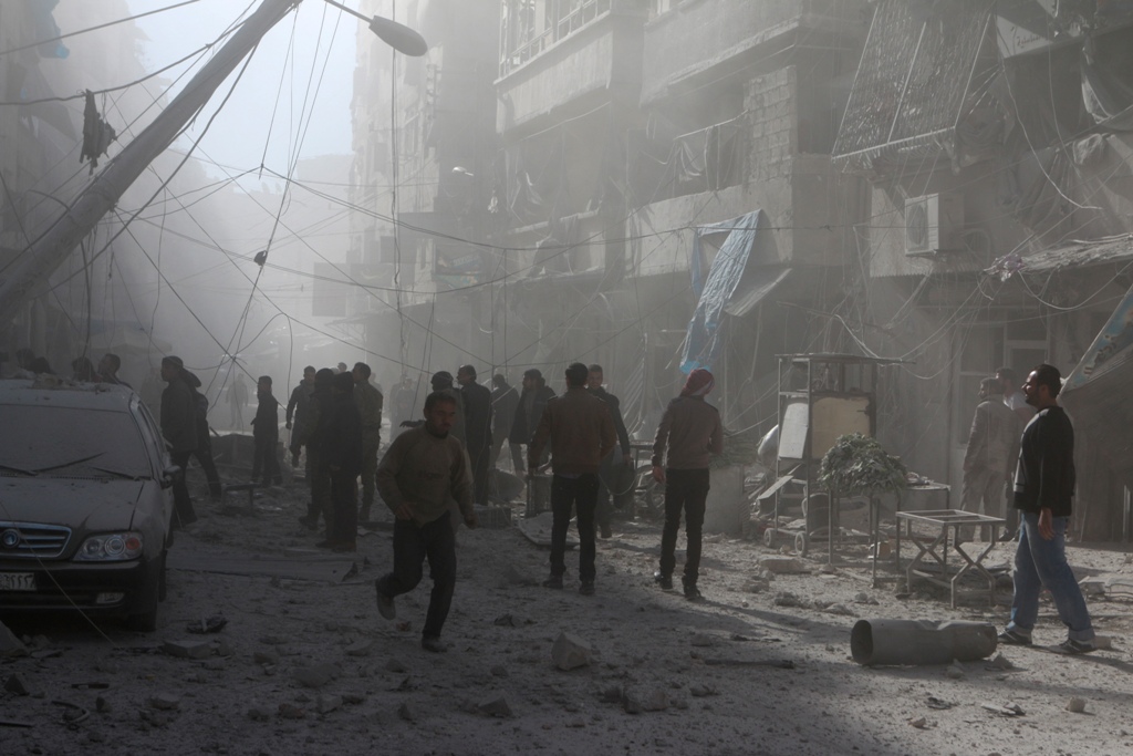 People walk on the debris buildings after the war crafts belonging to the Assad Regime carried out airstrikes on residential areas at Firdevs neighborhood in Aleppo, Syria on November 18, 2016. ( Jawad al Rifai - Anadolu Agency )
