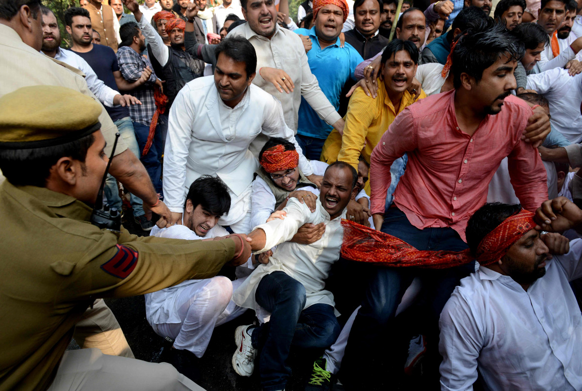 An Indian policeman pulls at a member of the Indian Youth Congress as he tries to detain him, during a protest against the demonetisation in New Delhi on November 18, 2016. India's government asked its citizens to put up with what it called the 