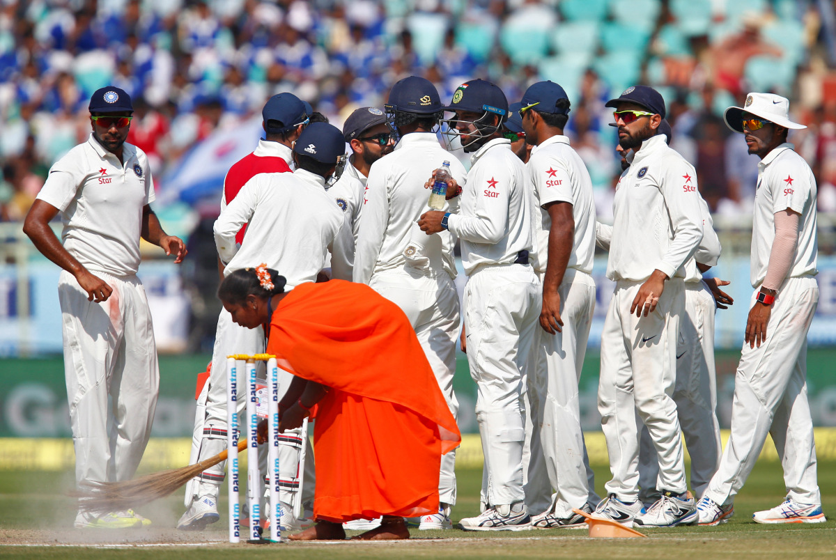  A ground staff uses broom to clean the pitch during a break. (Reuters/Danish Siddiqui)