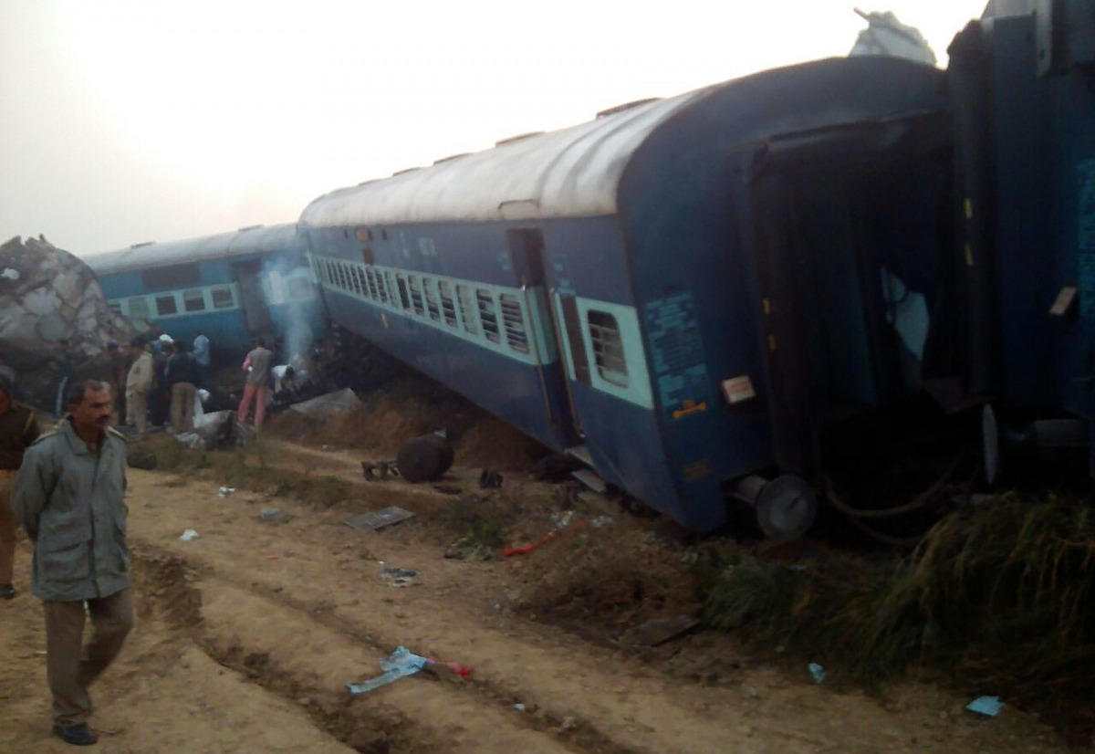 A man walks past the wreckage of an Indian train that derailed near Pukhrayan in Kanpur district on November 20, 2016. (AFP)