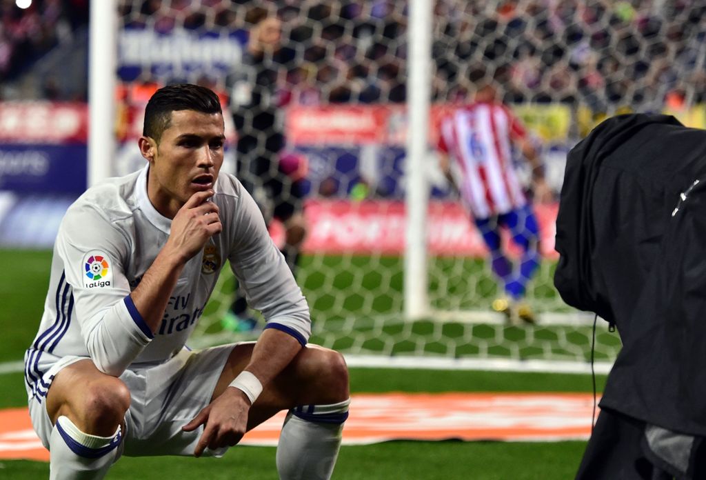 Real Madrid's Portuguese forward Cristiano Ronaldo poses in front of a TV camera as he celebrates after scoring during the Spanish league football match Club Atletico de Madrid vs Real Madrid CF at the Vicente Calderon stadium in Madrid, on November 19, 2