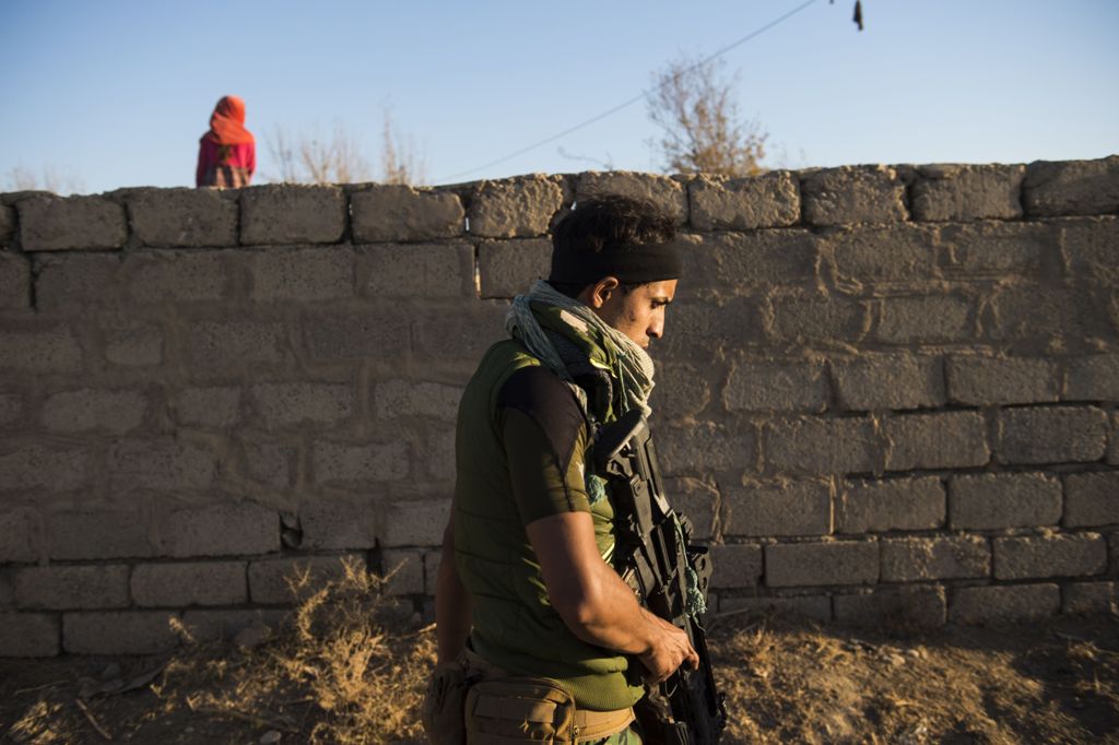A member of forces from Iraq's elite Rapid Response Division patrols at the site of a suspected mass grave on November 19, 2016 on the outskirts of the village of Tall Adh-Dhahab, located some 10 kilometres (6 miles) south of Mosul.  AFP / Odd ANDERSEN