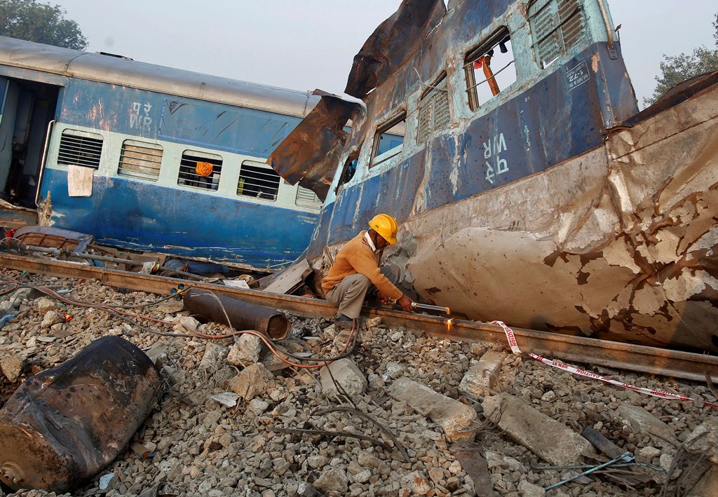 A railway employee cuts a railway track at the site of Sunday's train derailment in Pukhrayan, south of Kanpur city, India, November 21, 2016. REUTERS/Jitendra Prakash