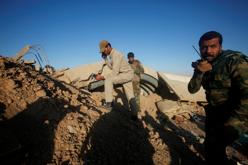 Members of the Shi'ite Badr Organisation fighters take cover behind a berm during a battle with Islamic State militants at the airport of Tal Afar west of Mosul, Iraq, November 20, 2016. REUTERS/Khalid al Mousily
