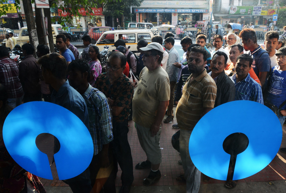 Indian customers queue to withdraw money from a State Bank of India ATM in Siliguri on November 21, 2016. Frustration is mounting in India over a cash crisis triggered by the withdrawal of all high-value notes from circulation. The shock November 8 move, 