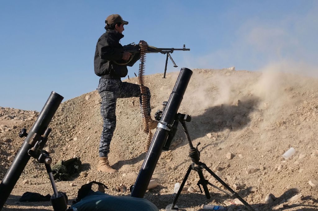 A member of the Iraqi Federal Police fires his weapon at an Islamic State (IS) group target on the front line near the village of Tall Adh-Dhahab, some 10 kilometres (6 miles) south of Mosul, on November 18, during a massive operation to oust IS jihadists