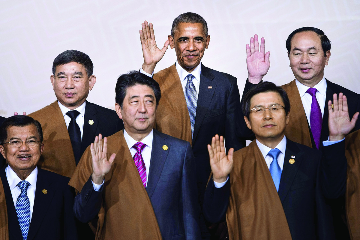 US President Barack Obama with Thailand's Deputy Prime Minister Prajin Juntong, Vietnam's President Tran Dai Quang; Indonesia's Vice President Jusuf Kalla, Japan's Prime Minister Shinzo Abe and South Korea's Prime Minister Hwang Kyo-Ahn wave during the tr