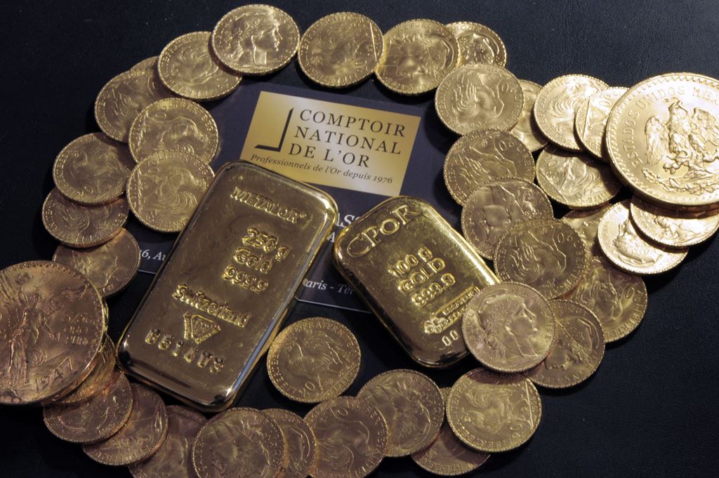 (FILES) This file photo taken on October 05, 2012 shows Gold bars and coins displayed on a table at the Comptoir National de l'Or, a shop that buys, sales and estimates gold and jewellery in Paris. AFP / BERTRAND GUAY

