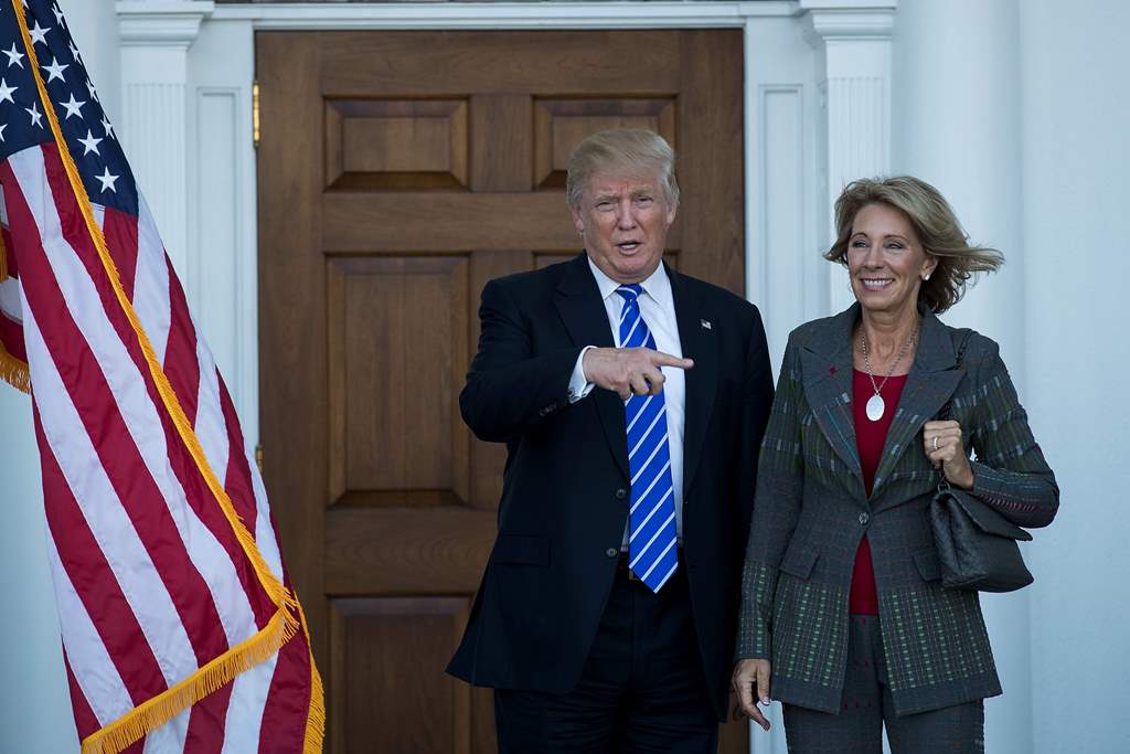 (FILES) This file photo taken on November 18, 2016 shows president-elect Donald Trump and Betsy DeVos after their meeting at Trump International Golf Club, in Bedminster Township, New Jersey. AFP / GETTY IMAGES NORTH AMERICA / Drew Angerera