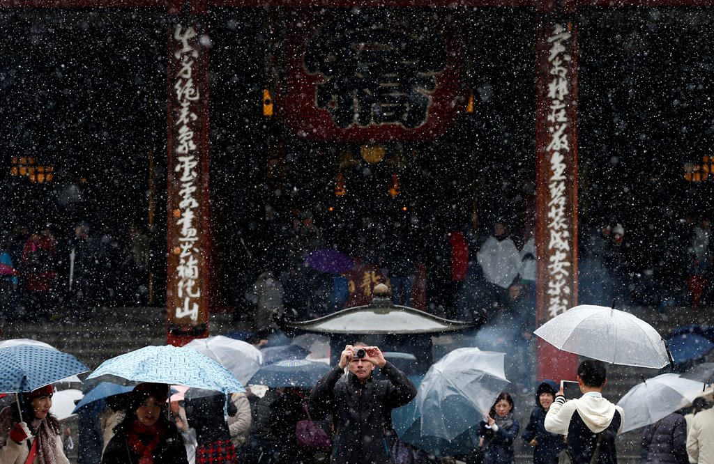 Tourists are seen during the first November snowfall in 54 years in Tokyo, at Senso-ji Temple in Tokyo's Asakusa district, Japan, November 24, 2016. REUTERS/Toru Hanai
