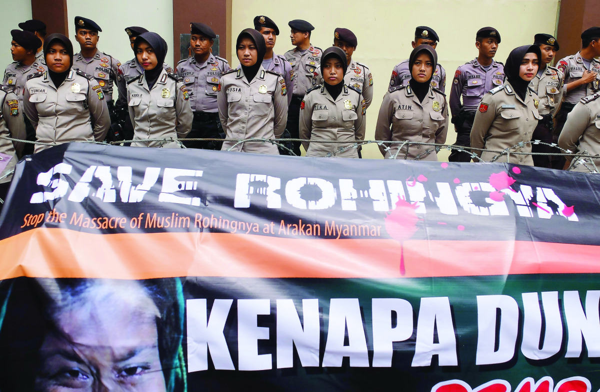 Indonesian police form a human barricade as Muslims hold a rally outside of Myanmar embassy against 