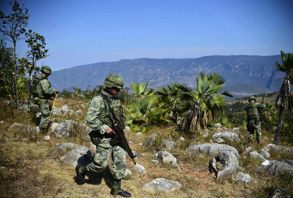 Mexican soldiers search for corpses in the surroundings of a mass grave, in the Zitlala municipality, Guerrero State, Mexico on November 25, 2016. AFP / RONALDO SCHEMIDT