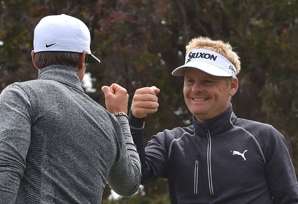 Thorbjorn Olesen (L) and teammate Soren Kjeldsen of Denmark bump fists during the third day of the World Cup of Golf on the Kingston Heath course in Melbourne on November 26, 2016. AFP / PAUL CROCK 
