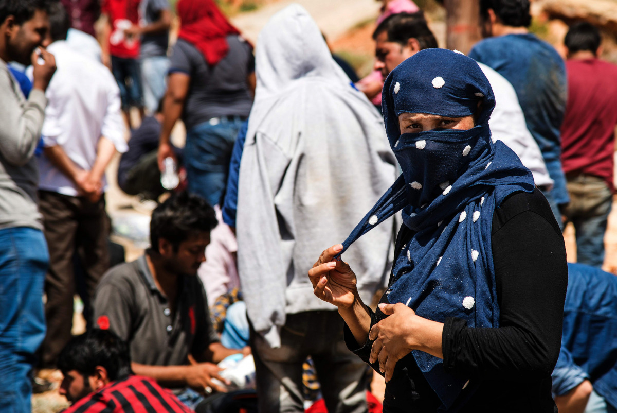 REPRESENTATIVE IMAGE: A woman pulls a corner of her headscarf as she stands with refugees and migrants upon their arrival with a boat near the village of Finokalia in the southern Greek island of Crete on May 31, 2016 (AFP)