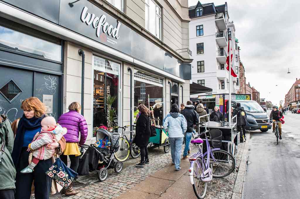 (FILES) This file photo taken on February 22, 2016 shows people walking past the Wefood supermarket that sells food past its sell-by date at Amager in Copenhagen, Denmark. AFP / SCANPIX DENMARK / Soren Bidstrup