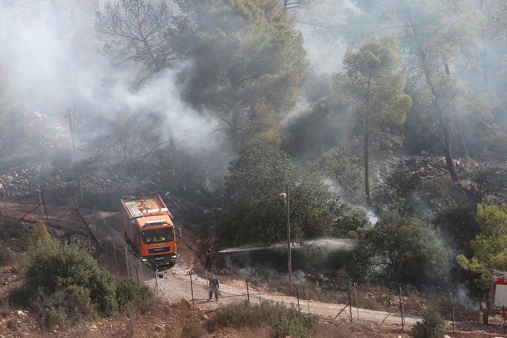 Israeli firefighters try to extinguish fire in a forest near the Halamish Jewish accommodation unit in Deir Nidham town of Ramallah, West Bank on November 26, 2016. (Issam Rimawi - Anadolu Agency)
