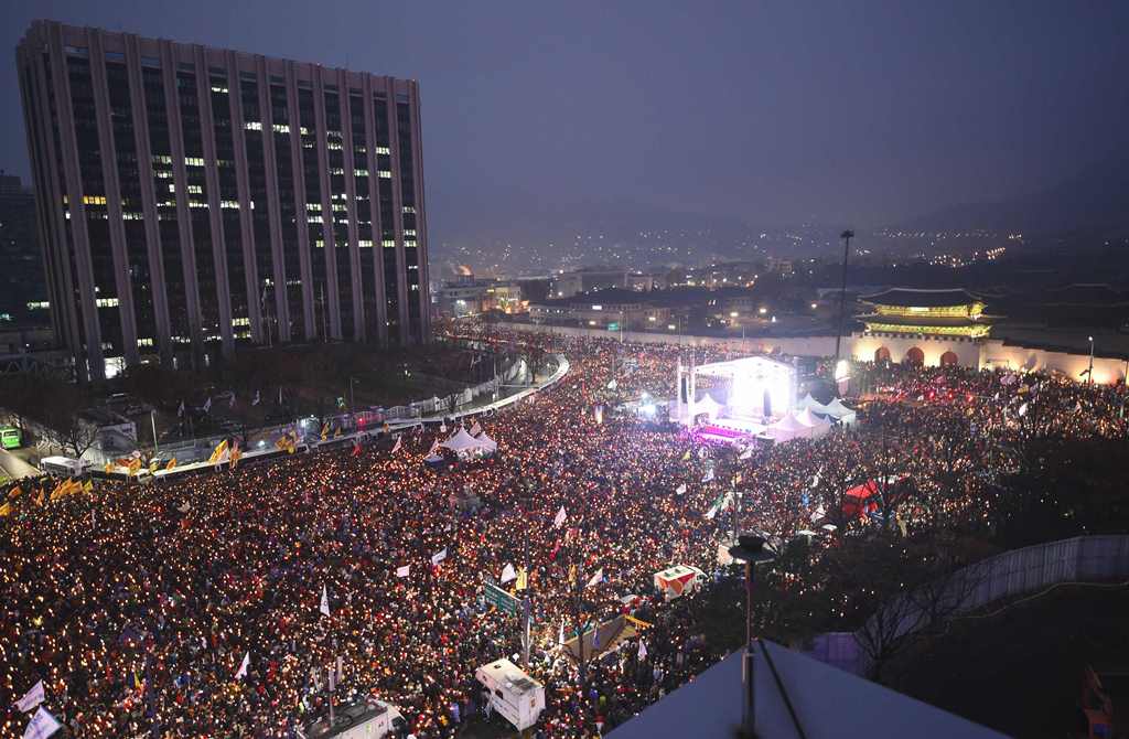 Protesters hold candles during a huge anti-government rally demanding the resignation of South Korea's President Park Geun-Hye in central Seoul on November 26, 2016. AFP / JUNG Yeon-Je