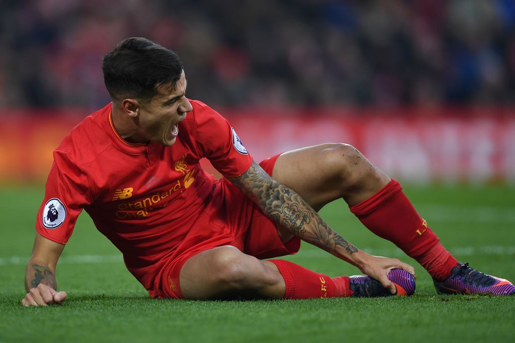 Liverpool's Brazilian midfielder Philippe Coutinho holds his foot as he lies on the pitch injured during the English Premier League football match between Liverpool and Sunderland at Anfield in Liverpool, north west England on November 26, 2016. AFP / Pau