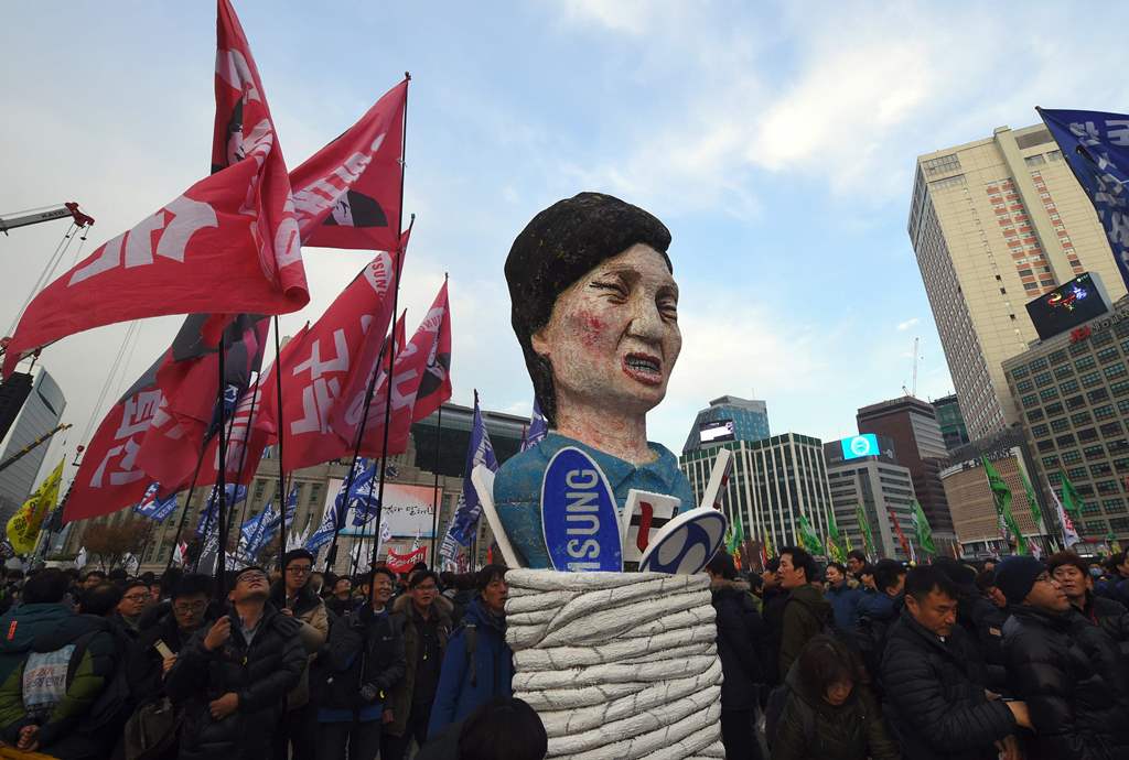 Protesters carry an effigy of South Korea's President Park Geun-Hye during an anti-government rally demanding the resignation of the president in central Seoul on November 30, 2016. asAFP / JUNG Yeon-Je