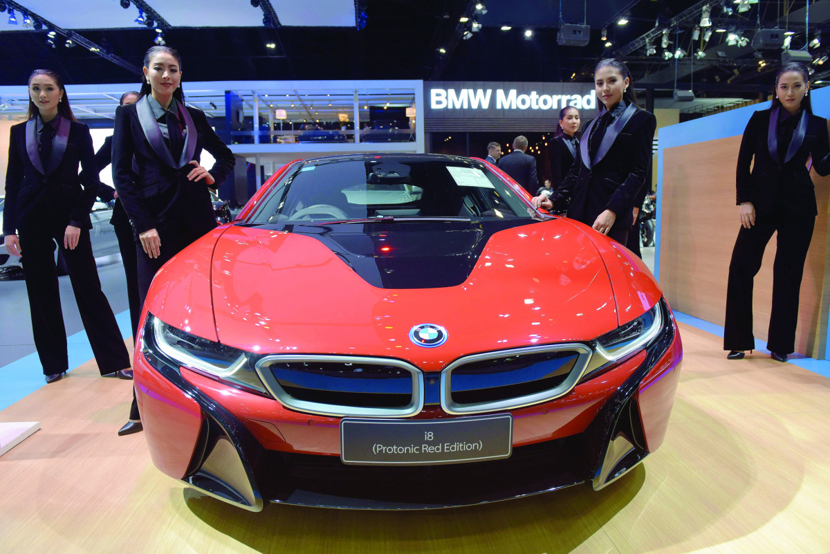 Thai models pose next to a BMW i8 car during the Motor Expo 2016 in Bangkok yesterday.