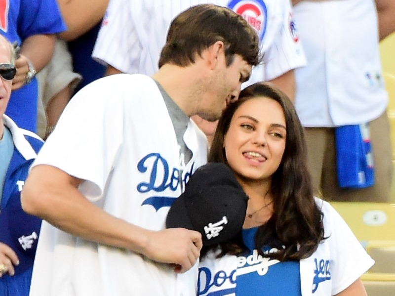 This file photo taken on October 18, 2016 shows Ashton Kutcher and wife Mila Kunis on the field after they announced the Los Angeles Dodgers starting lineup before game four of the National League Championship Series againt the Chicago Cubs at Dodger Stad