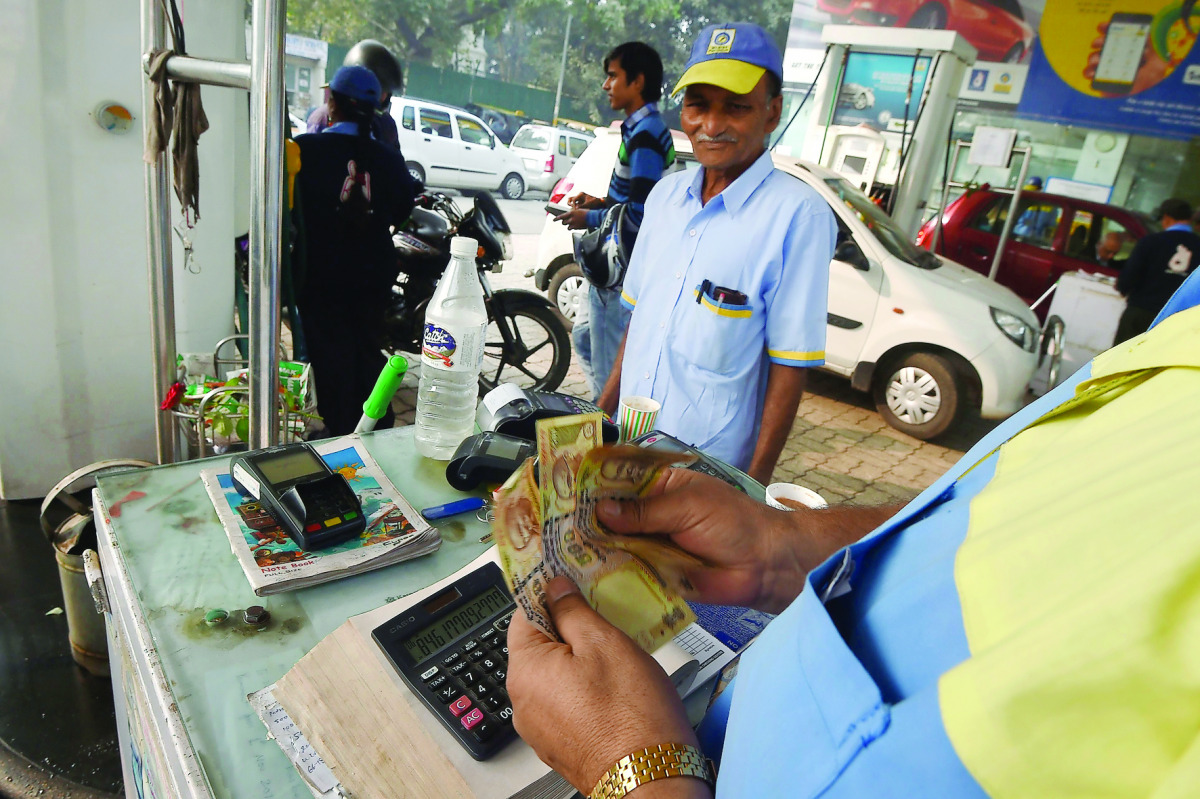A customer pays for fuel with old 500 rupee notes at a petrol station in New Delhi, yesterday. 
