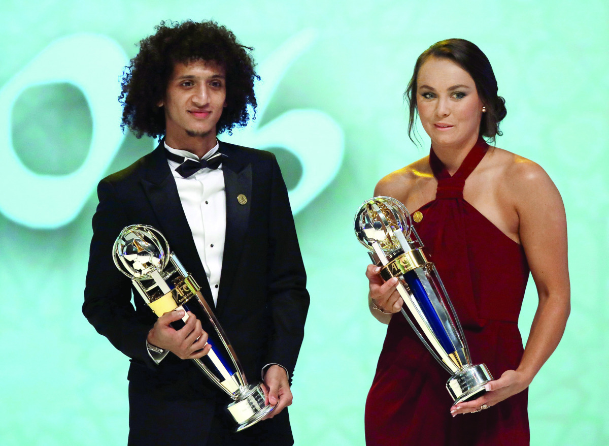 Emirate's Omar Abdulrahman (left), carrying the AFC Men's Footballer of the Year trophy, and  Australia's Caitlin Foord, carrying the AFC Women's Footballer of the Year, pose for a picture during the Asian Football Confederation's Annual Awards ceremony i