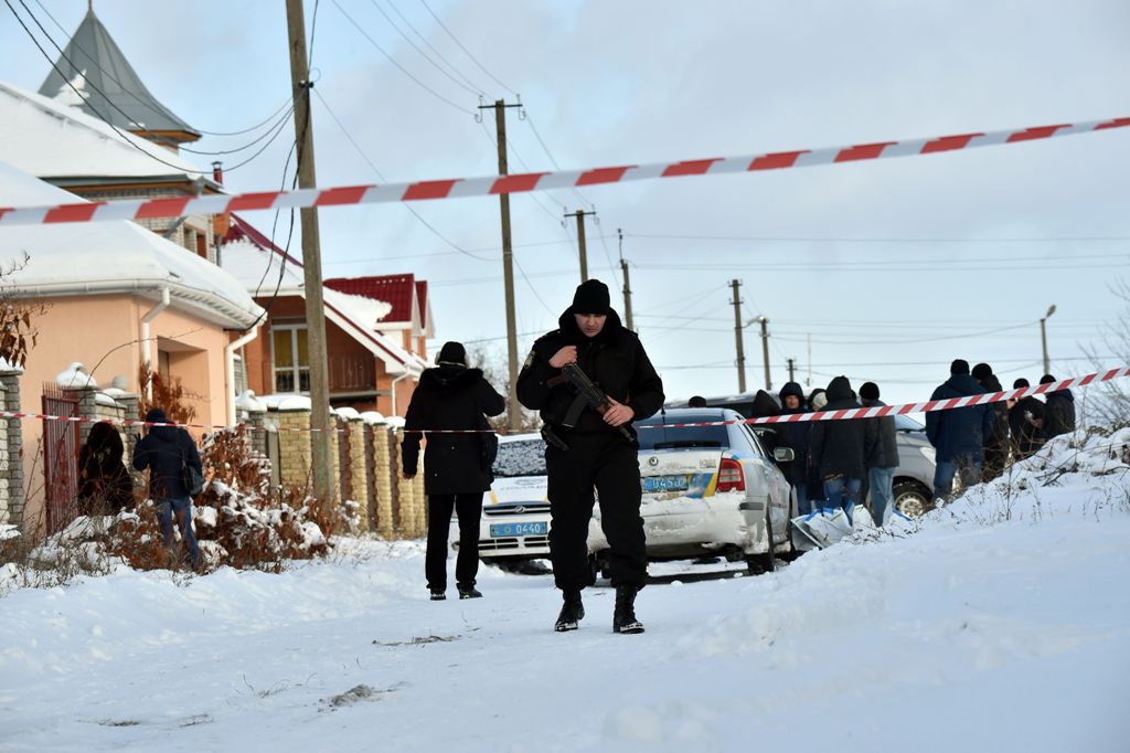 An armed policeman guards as the police experts examine crime scene in the small town of Knyazychy, some 30 kilometres east of Kiev, on December 4, 2016.
Five Ukrainian police were killed by friendly fire on December 4, 2016 in a deadly accident at a cri