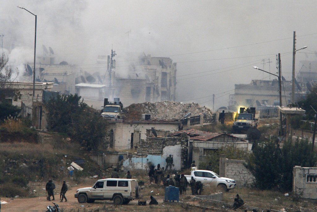 Pro-Syrian government soldiers shoot a weapon on the back of a vehicle near damaged buildings, in al-Izaa area in Aleppo, Syria December 5, 2016. REUTERS/Omar Sanadiki