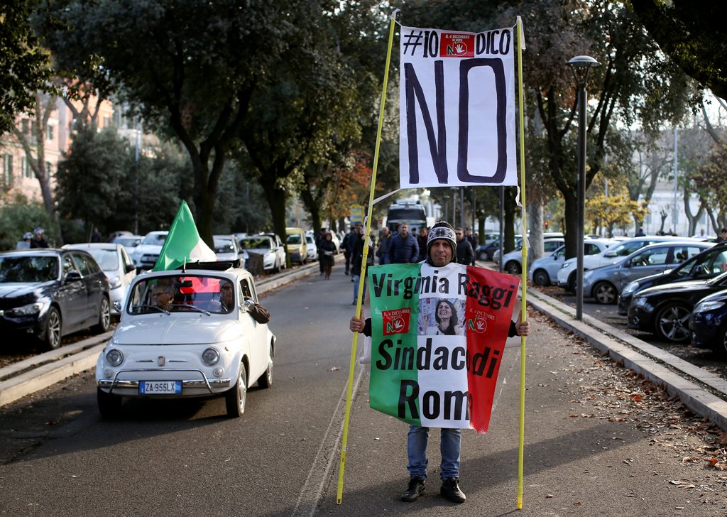 A man holds a banner reading 