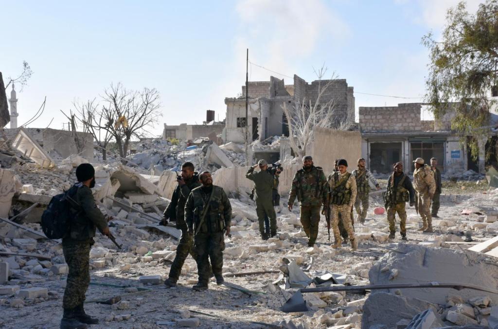 Syrian pro-government forces patrol the Masaken Hanano district in eastern Aleppo, November 27, a day after regaining control of the area from rebels. / AFP.