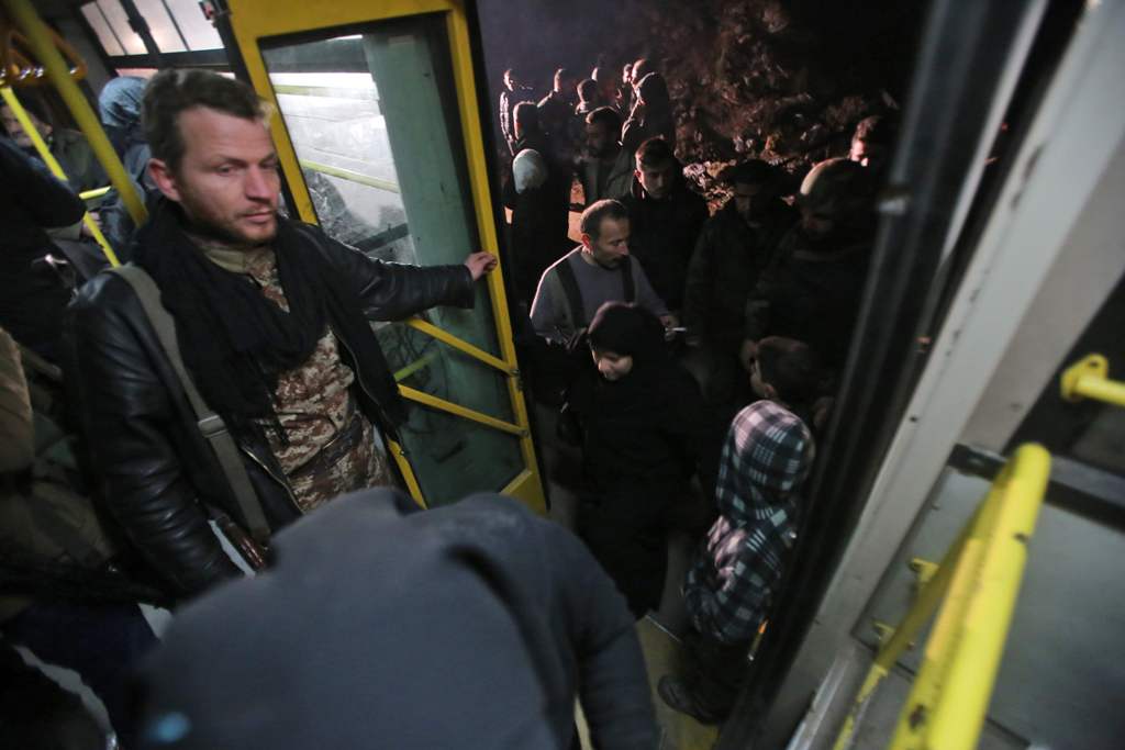 Syrian residents of the Old City of Aleppo stand in a bus at a crossing point during their evacuation to a distinct government-controlled area of the city early on December 7, 2016.  AFP / Youssef KARWASHAN
