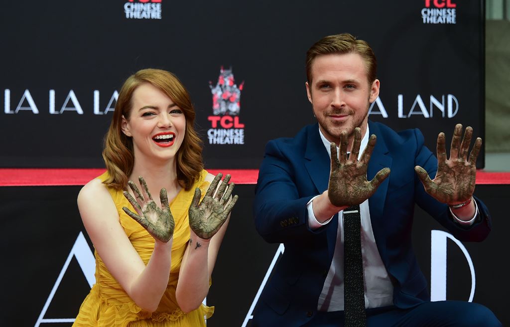 Actors Emma Stone and Ryan Gosling display their hands after placing them into the block of cement at their Hand and Foot prints ceremony in front of the TCL Chinese Theater in Hollywood on December 7, 2016 ahead of the release of the film LA LA Land set 