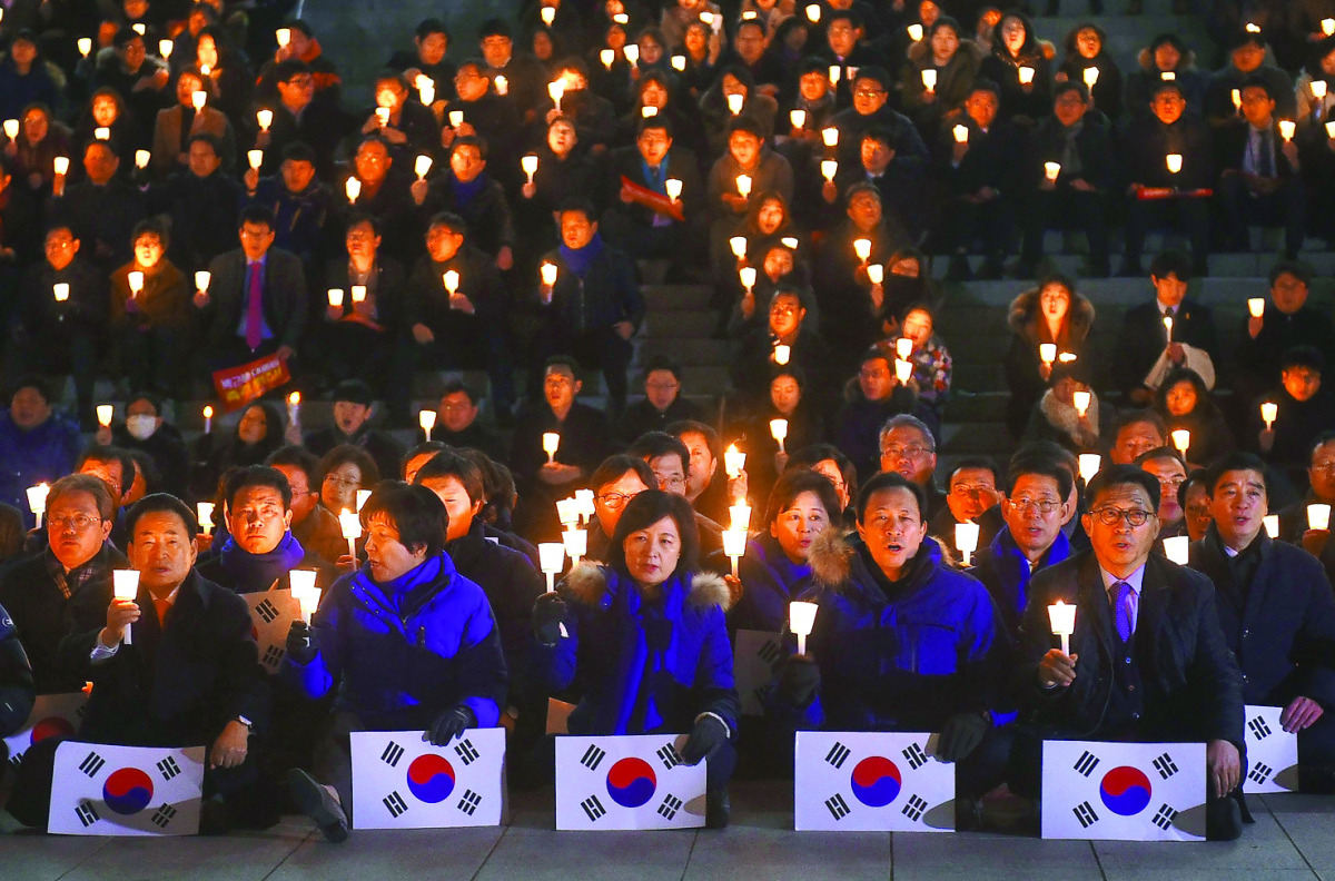 Lawmakers and members of South Korea's Democratic Party hold candles at a protest urging the impeachment of President Park Geun-hye at the National Assembly, in Seoul