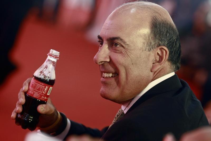 Chief Executive Officer and Chairman of Board of the Coca Cola Company Muhtar Kent holds a Coca-Cola bottle that is made in a Coca-Cola factory in Myanmar, during the factory's opening ceremony, outside of Yangon June 4, 2013. REUTERS/Soe Zeya Tun