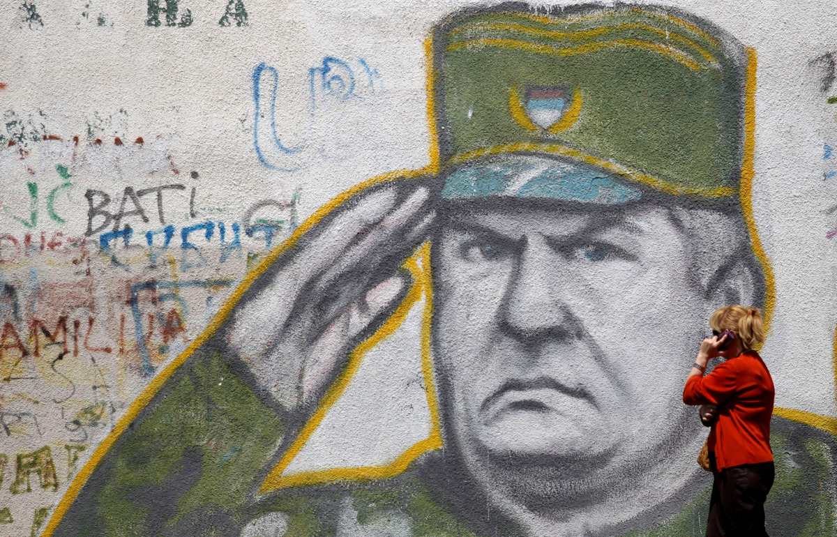 A woman walks past graffiti of Bosnian Serb wartime general Ratko Mladic in a suburb of Belgrade, Serbia, May 27, 2011. REUTERS/Stoyan Nenov