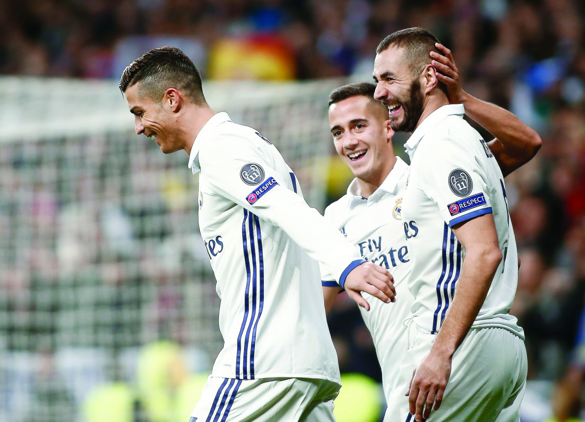 Real Madrid's Karim Benzema (right) celebrates with Cristiano Ronaldo (left) after scoring a goal against Borussia Dortmund during their UEFA Champions League match at Santiago Bernabeu Stadium in Madrid, Spain on Wednesday.