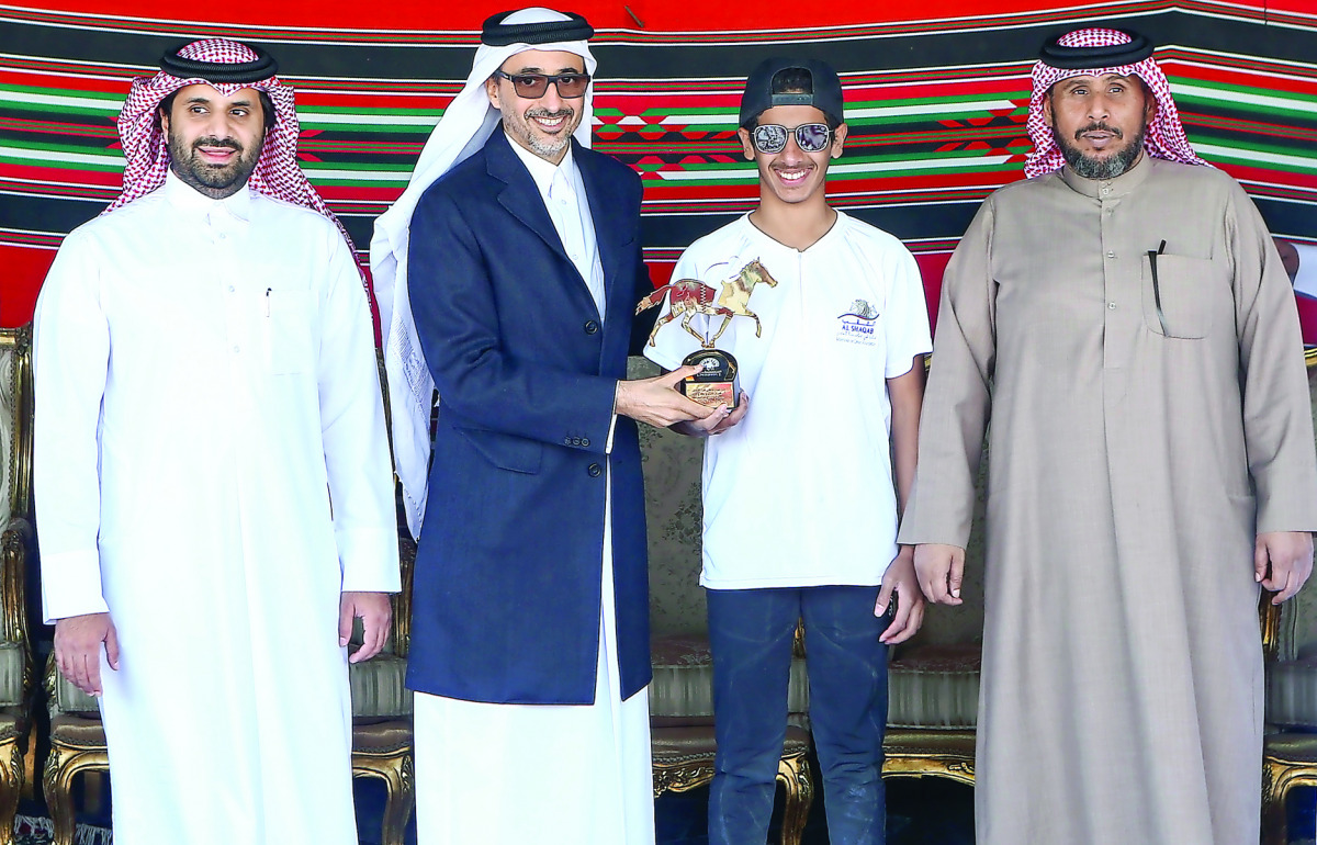 Minister of Culture and Sports H E Salah bin Ghanem Al Ali presents the winner's trophy to Saeed Hamad Saeed Juma during the presentation ceremony.