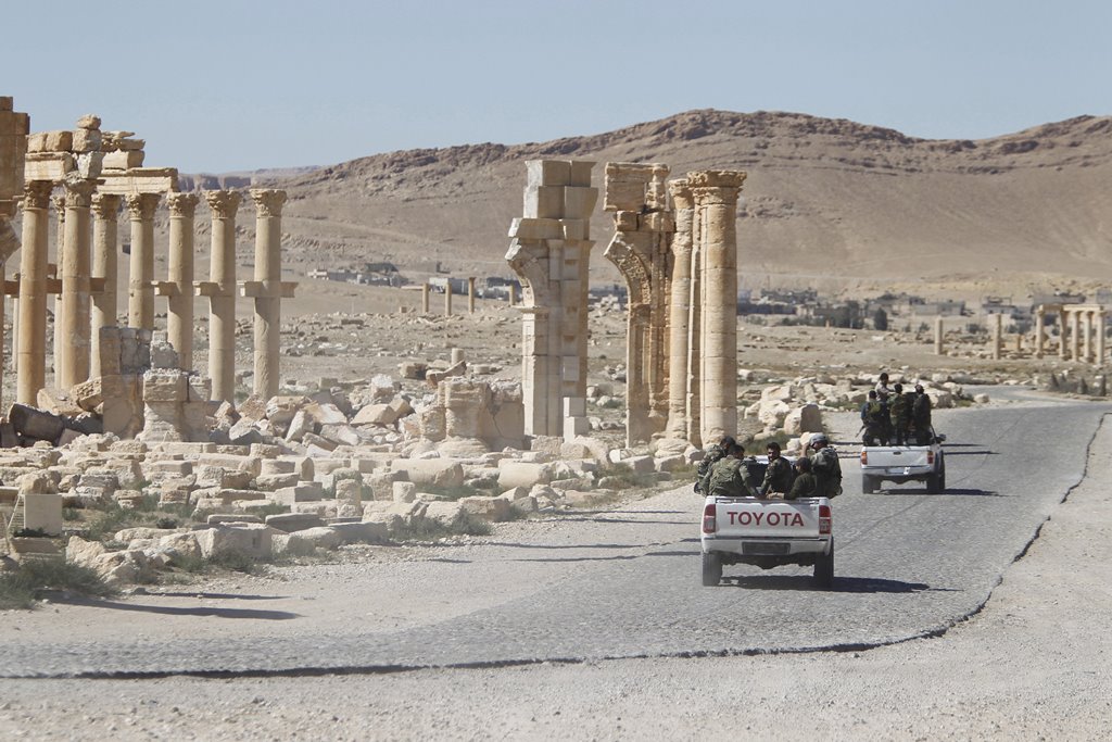 Syrian army soldiers drive past the Arch of Triumph in the historic city of Palmyra, in Homs Governorate, Syria in this April 1, 2016 file photo. Reuters/Omar Sanadiki/File Photo