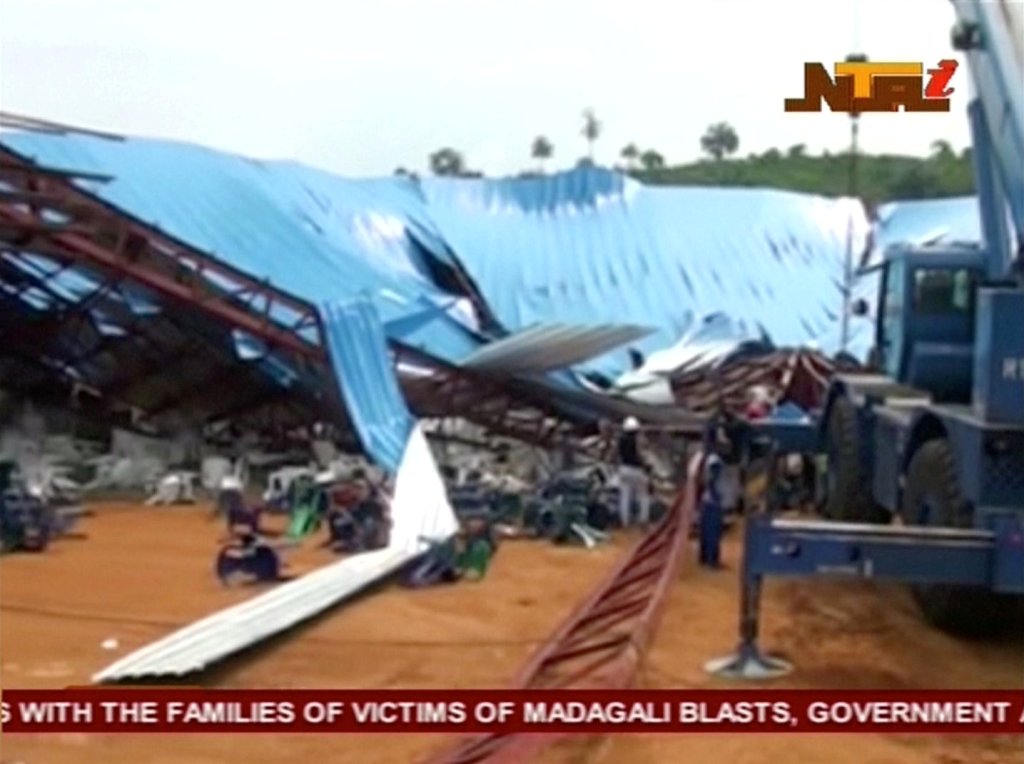 People stand near the remains of a church which collapsed during a service in the southern city of Uyo in Akwa Ibom state, Nigeria in this still image from video December 10, 2016. Video taken December 10, 2016. 
