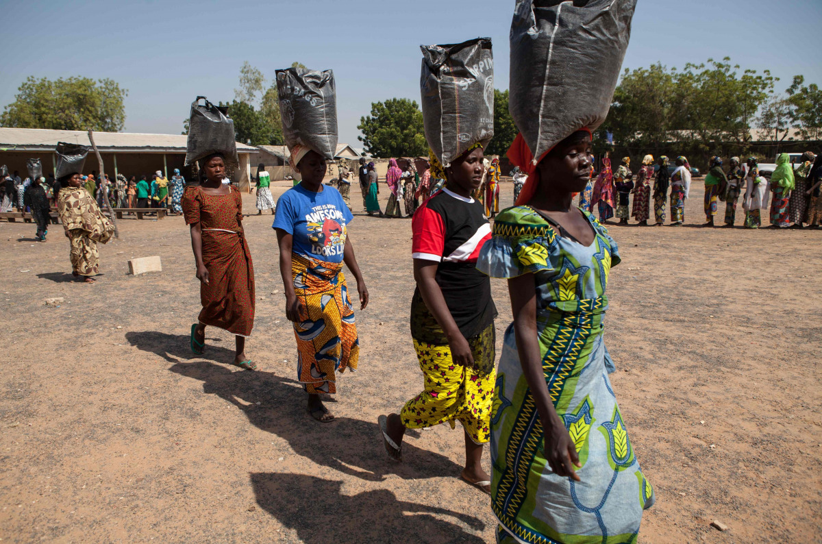 Displaced women carrying sacks of food aid received during a distribution at the Cathedral of Yola state capital of Adamawa, Nigeria (AFP)