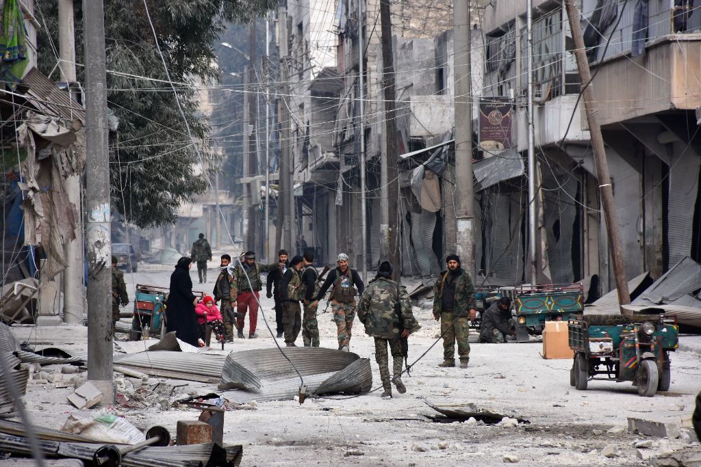Syrian pro-government forces patrol Aleppo's eastern al-Salihin neighbourhood on December 12, 2016 after troops retook the area from rebel fighters. / AFP / GEORGE OURFALIAN