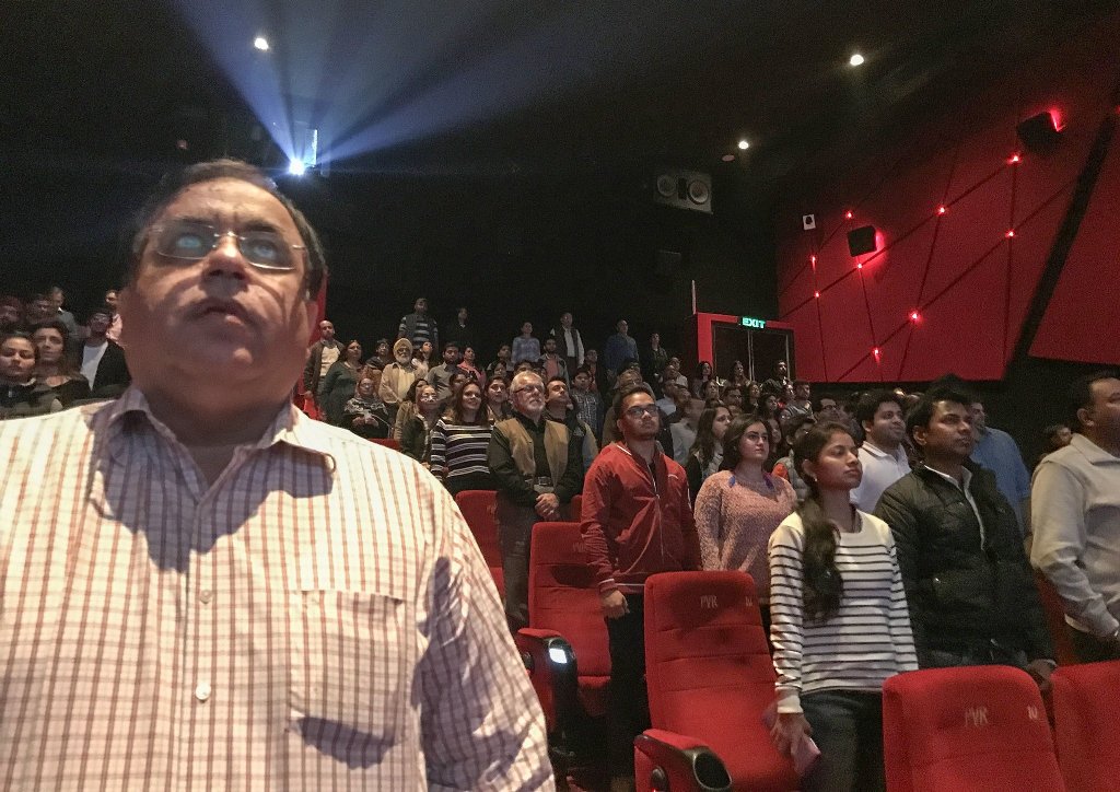 Moviegoers in New Delhi stood for the national anthem before a screening Dec. 4. A Supreme Court ruling requires viewers to stand respectfully while the anthem is played, unless they are physically unable. Credit Chandan Khanna/Agence France-Presse.
